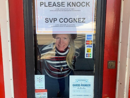 Tina Brooks looking out the window from inside the closed Peppermaster Shop Door.